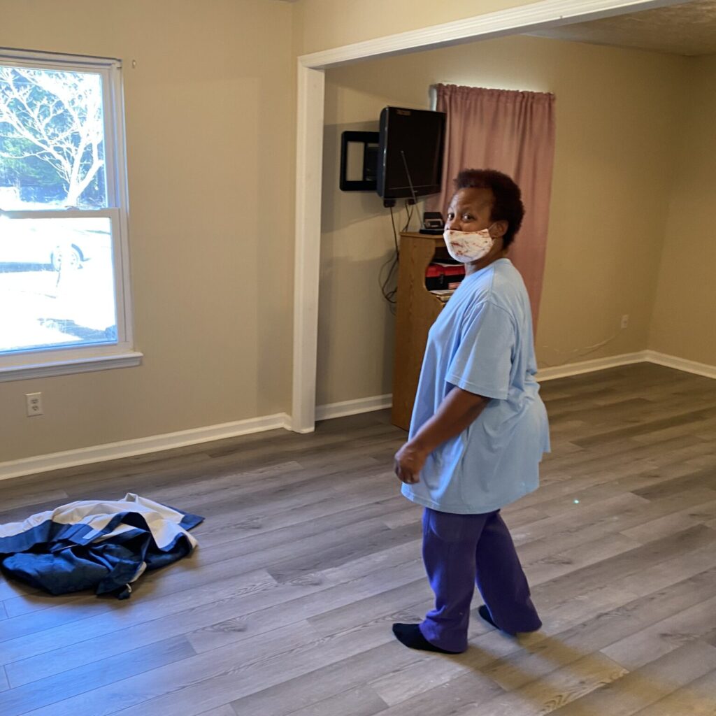homeowner Audrey stands on new laminate flooring